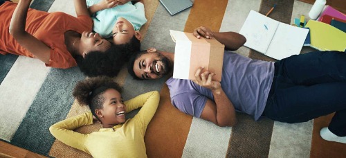 Young family lying on the floor in their living room.