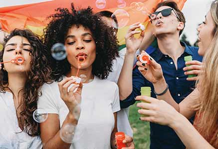 Group of young adults blowing bubbles.