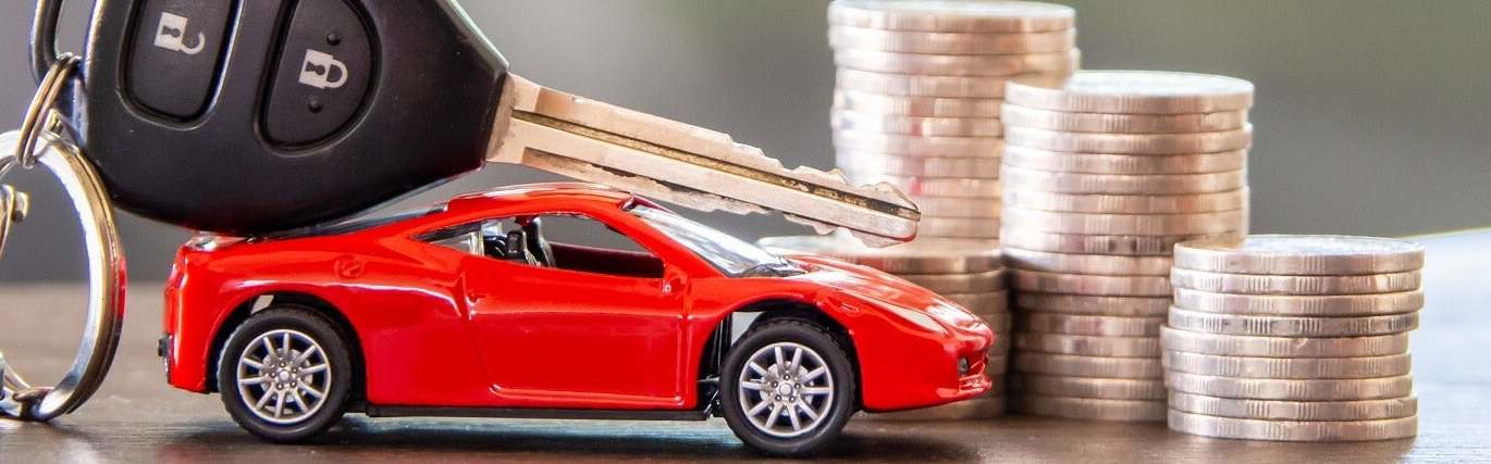 a key fob on top of a toy car with a stack of coins