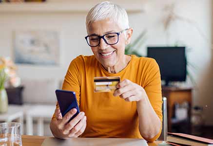 Woman using her credit card while shopping on her phone.