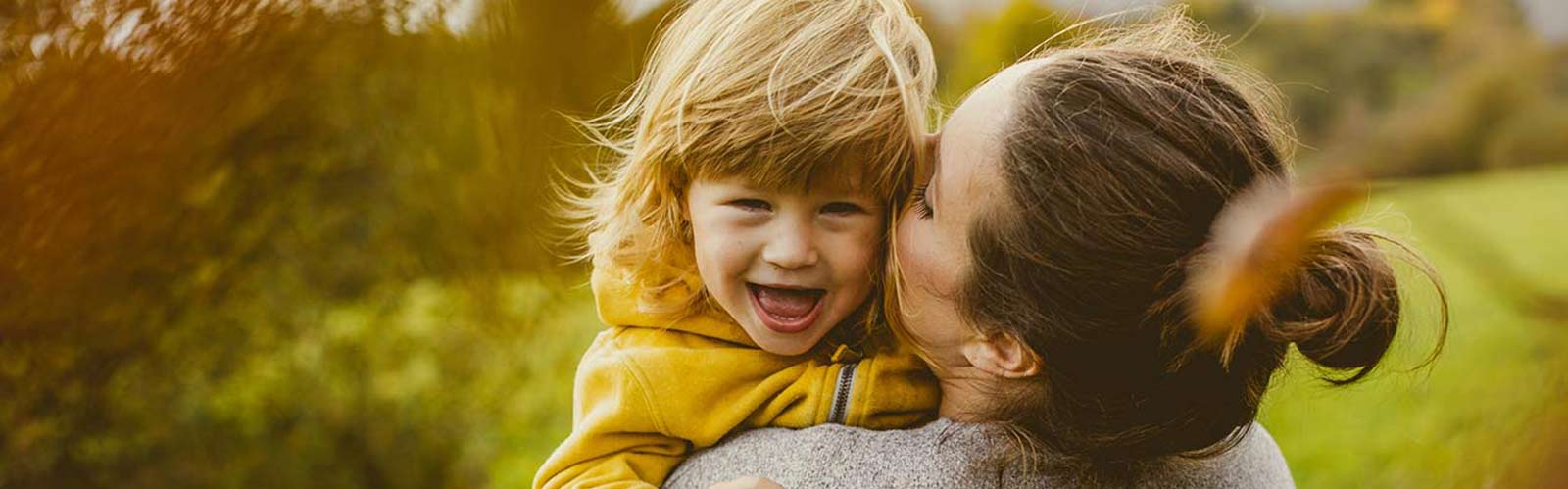 a mother and child hugging outdoors