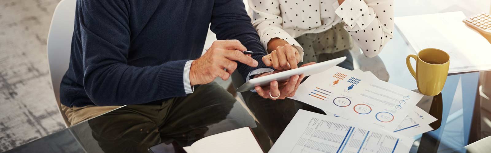 two people sitting at a desk working on their finances header image