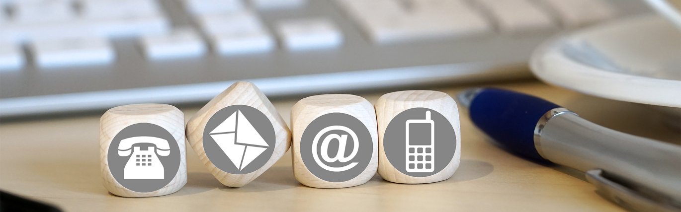 four wooden cubes with a phone, envelope, @ symbol and mobile phone icons